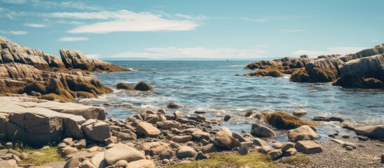 Aufkleber - A rugged coastline featuring a variety of rocks and patches of grass scattered along the shore. with copy space image. Place for adding text or design
