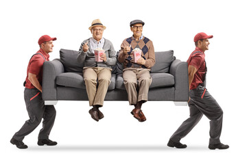 Wall Mural - Movers carrying a sofa with elderly men sitting and eating popcorn