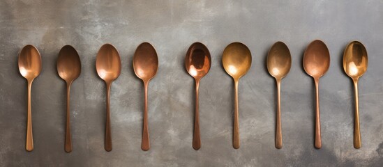 Leinwandbilder - Multiple vintage coffee spoons made of bronze arranged neatly on a concrete surface, suitable for food photography props with empty space for text. with copy space image