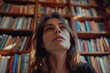 © vefimov - A woman stands in front of a bookshelf filled with books, perfect for use as a stock image for literary or educational themes