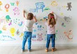 © HanThar Fusion - Two children drawing with colors on a white wall with various child drawings