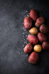 Wall Mural - Raw uncooked potato on dark table