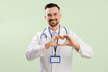 Sticker - Male doctor making heart with his hands on green background