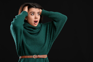 Wall Mural - Scared young woman on black background