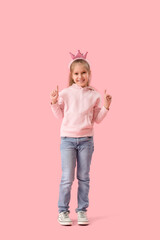 Poster - Cute little girl in crown and hoodie pointing at something on pink background