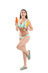 Poster - Beautiful young woman with bottles of sunscreen cream on white background