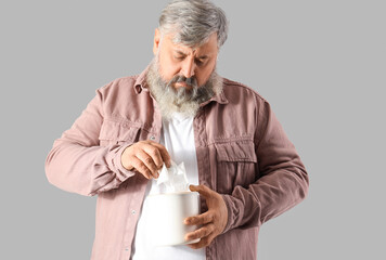 Poster - Portrait of sad senior man with tissues on grey background