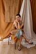 © Tania Cervian/Stocksy - Stylish slim woman model sitting on chair