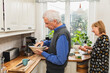 © Diego Martin/Stocksy - Senior couple preparing morning breakfast