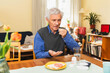 © Diego Martin/Stocksy - Focused senior man taking pills at home