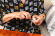 © Diego Martin/Stocksy - Hands of a senior woman fixing electrical plug