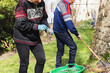 © Diego Martin/Stocksy - Senior couple cutting weeds and cleaning up at garden