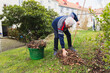 © Diego Martin/Stocksy - Senior man cleaning with wire broom his garden
