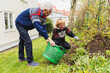 © Diego Martin/Stocksy - Senior couple cutting weeds and cleaning up at garden