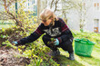 © Diego Martin/Stocksy - Senior woman cutting weeds at her backyard