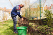 © Diego Martin/Stocksy - Senior man cleaning with wire broom his garden