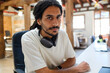 © Jimena Roquero/Stocksy - Portrait of young man in startup office with headphones