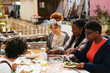 © BONNINSTUDIO/Stocksy - Diverse friends having lunch in community garden