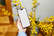 © Artem Podrez/Stocksy - Phone White Screen Mockup with Yellow Blooms. Photo with flash