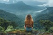 © Aliaksandr Siamko - A woman sits on a rock in a forest, looking out over the mountains