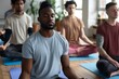 © Aliaksandr Siamko - A group of men are sitting on yoga mats and meditating