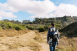© Serena Burroughs/Stocksy - young father hiking in san diego california with son in baby carrier