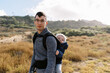 © Serena Burroughs/Stocksy - young father hiking in san diego california with son in baby carrier