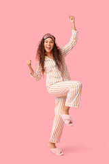 Sticker - Beautiful young happy African-American woman in pajamas with mask on pink background