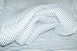 © Colour Laboratory/Stocksy - Bed with striped pattern duvet, mattress, pillow with hard flashlight