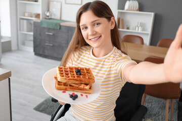 Poster - Young woman in wheelchair with tasty waffles taking selfie at home, closeup