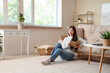 © Pixel-Shot - Beautiful young woman reading book and sitting on floor at home