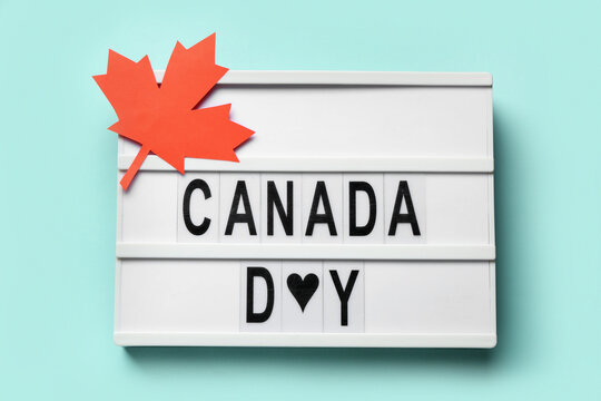 Maple leaf and sign with text CANADA DAY on cyan background