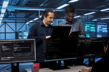 Poster - coworkers in data center using laptop and tablet to find firewall misconfigurations affecting server