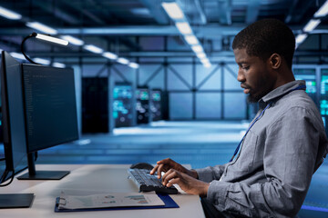 Poster - employee checking for signs of imminent tech failure in data center supercomputers. african american