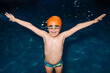 © VICTOR TORRES/Stocksy - Joyful young boy celebrates in the swimming pool at night