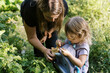 © Serena Burroughs/Stocksy - happy mother with her children in their vegetable garden together
