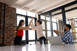 © Wavebreak Media - Asian businesswoman and Caucasian female woman high-fiving in modern office
