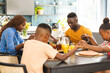 © Wavebreak Media - African American family saying grace around table, preparing for lunch