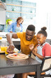 © Wavebreak Media - Young African American man and girl enjoying lunch together at dining table