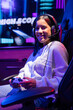 © Wavebreak Media - Biracial young woman wearing headset playing video games, smiling at camera, at home