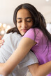 © Wavebreak Media - Two young biracial sisters hugging closely, showing strong bond of friendship, at home