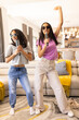 © Wavebreak Media - Two biracial young sisters sing karaoke together in casual outfits and sunglasses, at home