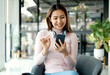 © Orathai - Female CEO in casual wear smiling and using smartphone working Shown on the digital screen analyze and calculate the planning strategy for modern business
