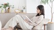 © mapo - ソファで本を読む女性