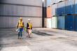 © artitwpd - Caucasian woman supervisor and Indian man industrial worker work with tablet at a container yard. Shipping business management and international goods import-export. Concept of Logistic operation.