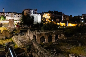 Rome, Italy - April 09, 2024: Night view of the ruins of the Roman Forum in Rome with tourists crowding its surroundings in Rome, Italy