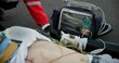 © CineLens/peopleimages.com - Accident, paramedic and chest with defibrillator for help, emergency and healthcare on road. First responder, medic and male victim with support, injury and life saving on tarmac with protection