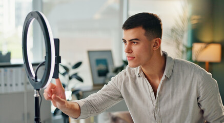 Poster - Man, light and phone for live stream in home, hand for notification with internet. Online, male influencer and broadcast in house with mobile app, creative review for audience with media technology