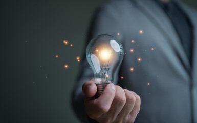 Aufkleber - Businessman holding illuminated lightbulb, idea, innovation and inspiration with glowing, smart intelligent creativity with bulbs, Motivation and innovation concept