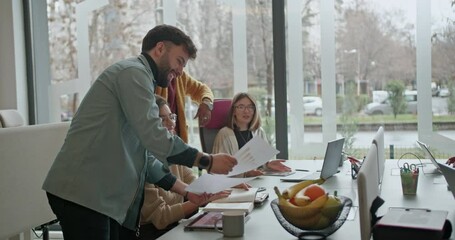 Wall Mural - A group of diverse business employees is discussing marketing and sales strategies around a conference table, showcasing their collaborative approach to problem-solving and decision-making.